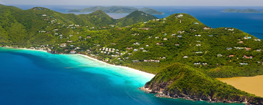 A tropical island features rolling hills blanketed with trees